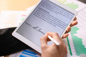 Electronic signature. Man using stylus and tablet at table, closeup