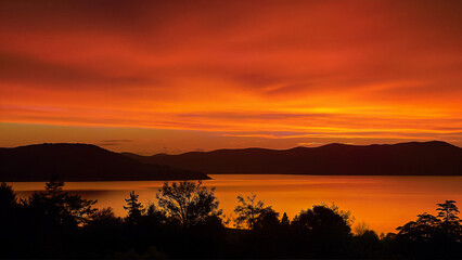 Obraz premium Vivid Sunset Over Calm Mountain Lake