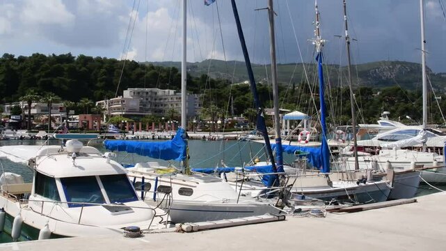 Experience the beauty of Agii Apostoli marina in Greece, featuring stunning views of the landscape, anchored boats, and a tranquil atmosphere inspired by the sea and mountains.