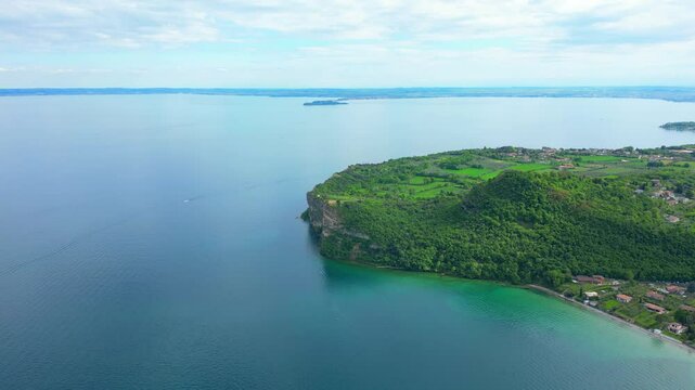Aerial view of Rocca di Manerba with the cliff overlooking Lake Garda in the province of Brescia, Lombardy, Italy. The video expresses serenity and peace while waiting for the summer season that is ce