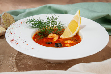 Seafood Solyanka Soup with Lemon and Dill in White Plate
