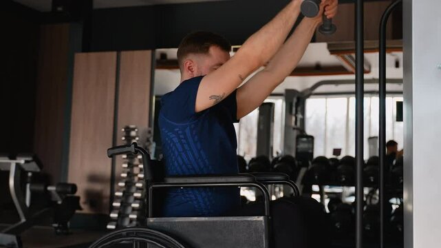 Man in wheelchair using cable machine in gym