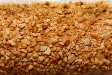 Close-up of crushed peanut-covered dessert surface texture in warm lighting
