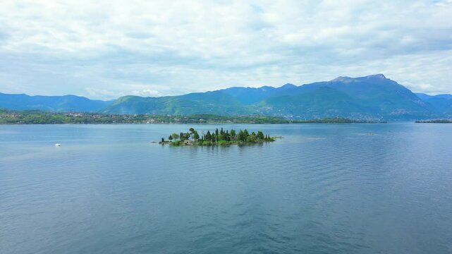 Aerial view of Isola Dei Conigli in Manerba with the cliff overlooking Lake Garda with crystal clear water. We are in the province of Brescia, Lombardy, Italy. The video expresses serenity and peace