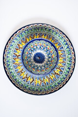 dish with national ornament on white background. Asian patterns on plate. Top view.
