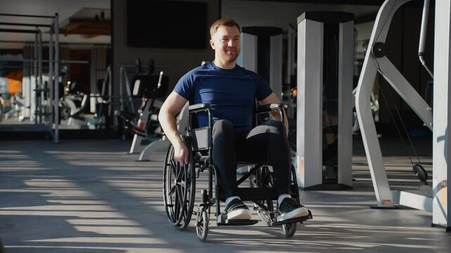 Confident man in wheelchair moving through gym space