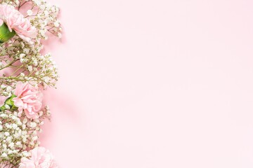 Bouquet of white gypsophila and pink carnations on a pink background in the corner, copyspace