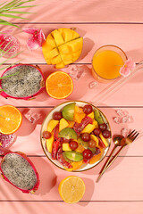 Fruit kitchen background with ingredients for making salad. Dragon fruit, mango, kiwi, orange, nuts and dried apricots, exotic fruits for a healthy lifestyle, advertising banner for a cafe, restaurant