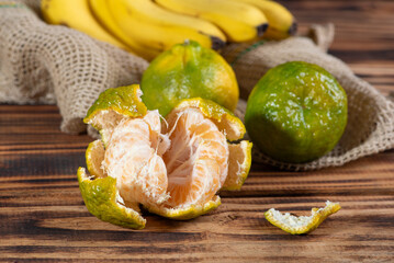 Oranges and Bananas, oranges and bananas positioned on a rustic wooden surface and dark background, selective focus.