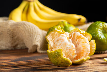 Oranges and Bananas, oranges and bananas positioned on a rustic wooden surface and dark background, selective focus.