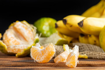 Oranges and Bananas, oranges and bananas positioned on a rustic wooden surface and dark background, selective focus.