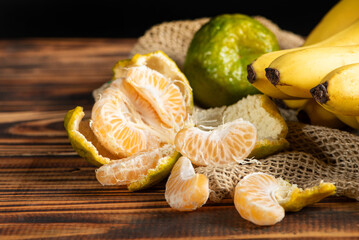 Oranges and Bananas, oranges and bananas positioned on a rustic wooden surface and dark background, selective focus.