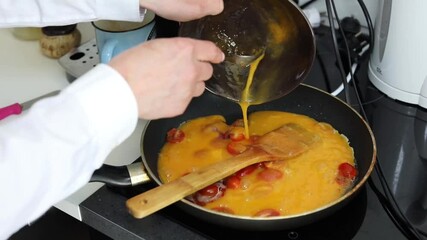 Woman cooking homemade omelet with bacon and tomatoes in cozy kitchen