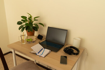 Fototapeta premium Home workspace with various items such as laptop, diary, glasses, headphones, etc. Work from home, remote work.