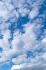 White clouds in the blue sky on a bright sunny day.