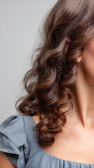Fototapeta premium close-up of soft frizz-free curls cascading on shoulders, white seamless background.