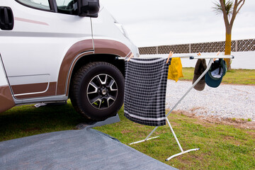 Camper van exterior with drying laundry on rack outdoors in campsite