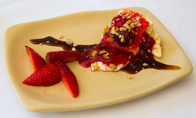 Tasty dessert - cake with custard and cherry topping served with fresh strawberry