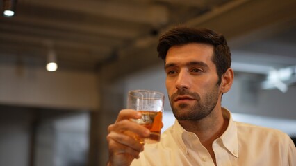 Profile closeup of smiling smart man in white shirt drinking cocktail in Old fashioned of special party beverage vibrant at nightclub on Friday meeting night time at luxurious counter bar. Vinosity.