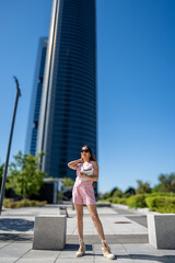 Fototapeta premium Businesswoman holding tablet and posing in Cuatro Torres Business Area in Madrid