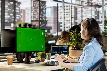 Female general director uses copy space mockup at the workstation, studying online analytics for a...