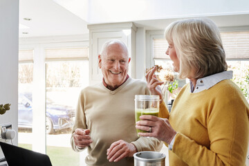 Home, smile and laptop with senior couple, health and retirement with connection, website information and internet. Apartment, old man and elderly woman with a pc, diet plan and email with support