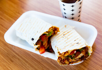 Traditional turkish Durum kebab with meat, vegetables and sauce in lavash flatbread