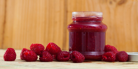 Image of tasty raspberry jam in jar and fresh berries on wooden surface, nobody
