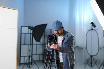 Man with professional video camera in studio