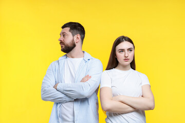 Resentful couple with crossed arms on yellow background