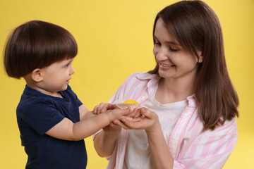Mother and baby eating tasty mochi on yellow background