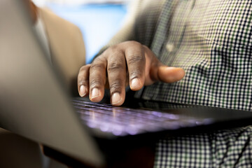 Office clerk reading company documents on laptop, checking progress on customer commissioned project tasks. Staff member comparing key data statistics on notebook after business audit