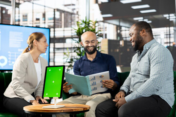 Green screen device next to smiling colleagues doing brainstorming, coordinating company administrative operation. Close up of mockup tablet used by joyous team of office clerks reviewing data