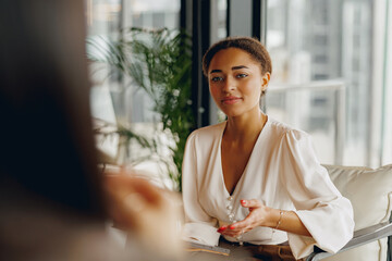 A focused woman engages in a deep conversation in a bright, modern office, showcasing her...