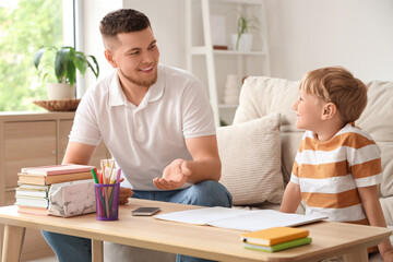 Fototapeta premium Father and his son doing homework together at home