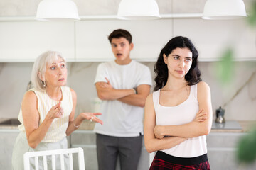 Elderly woman mother and young guy during family quarrel accuse adult daughter, prove her wrong