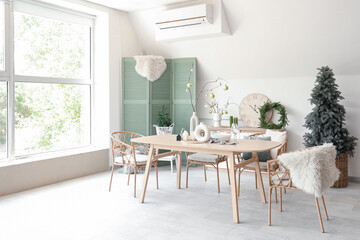 Interior of dining room with festive table setting and Christmas decorations