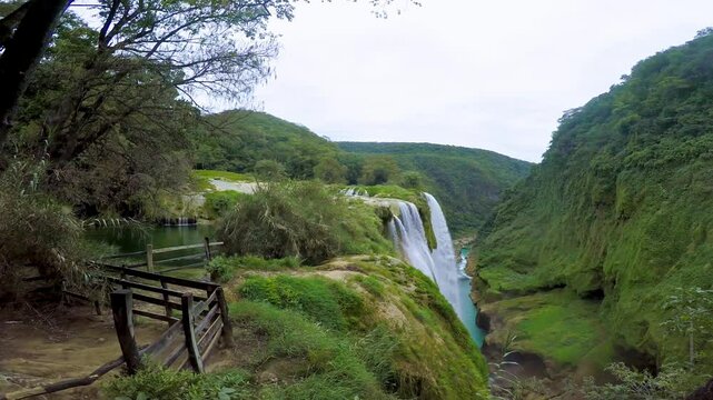 Tamul waterfall cascading into turquoise river in san luis potosi