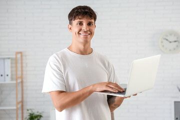 Young man working with laptop in office