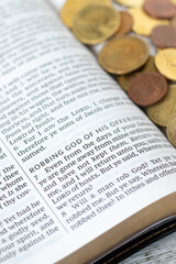 Holy bible book with coin money. Christian tithing and blessing from God Jesus Christ. Close-up. Selective focus. Biblical concept.