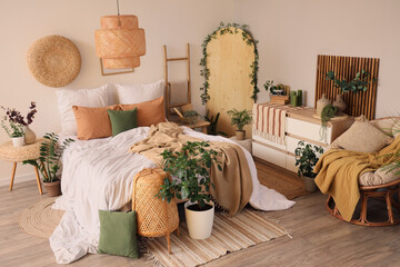 Interior of cozy bedroom with comfortable bed, ladder and plants