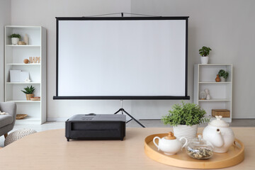 Interior of light room with projector screen, shelf units and dining table