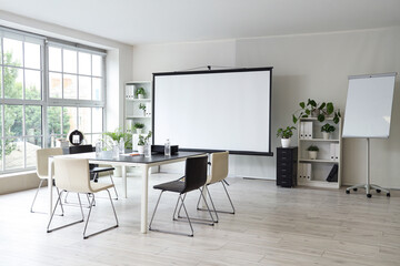 Interior of office with projector screen and meeting table