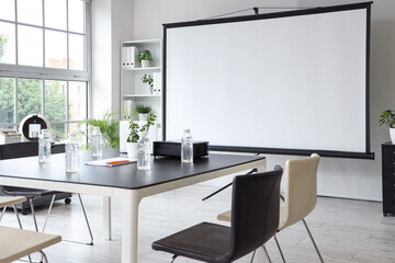 Interior of office with projector screen and meeting table