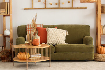 Interior of light living room with autumn decor, sofa and table