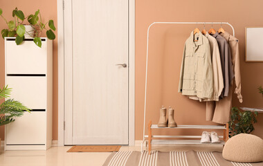 Interior of hallway with clothes rack, drawers and door