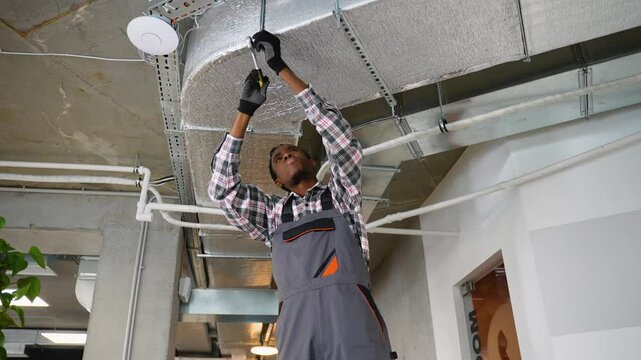HVAC technician working on office ventilation system