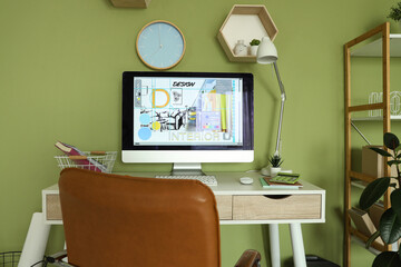 Interior designer's workplace with computer monitor near green wall in office