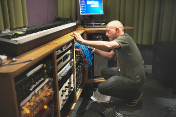 Studio, man and producer with cables, music and maintenance with instruments, audio mixing and dj....