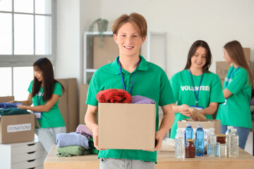 Young male volunteer with donations for poor people in center